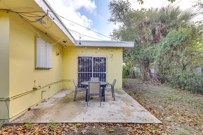 a table and chairs on the patio of a yellow house at Game Day Made Easy Home 3 Mi to Hard Rock Stadium in Miami Gardens