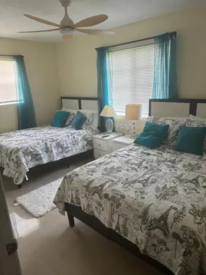 a bedroom with two beds and a ceiling fan at Miramar near Hard Rock stadium in Miramar