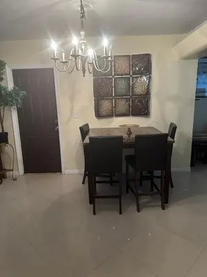 a dining room with a table and chairs and a chandelier at Miramar near Hard Rock stadium in Miramar