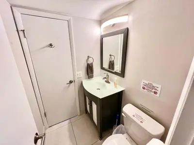 a small bathroom with a sink and a toilet at Modern 2 bedroom condo with heated pool, free parking spot at a 5 minute walk to the beach! in Sunny Isles Beach