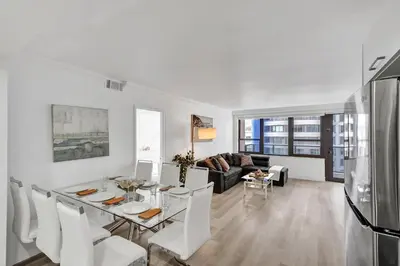 a white living room with a table and chairs at Gorgeous Ocean View 3BD Condo in Beachfront Resort 907 in Miami Beach