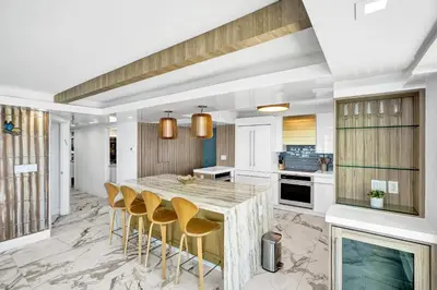 a kitchen with a large marble table and stools at Luxury Oceanfront Condo 2BR 2.5BA with 700Sqft Terrace Sauna Resort Amenities and Pools 1501 in Miami Beach