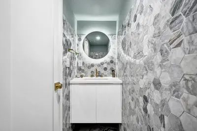 a bathroom with a white sink and a mirror at Luxury Oceanfront Condo 2BR 2.5BA with 700Sqft Terrace Sauna Resort Amenities and Pools 1501 in Miami Beach