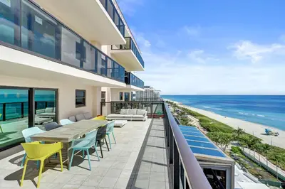 a balcony with a table and chairs and the ocean at Luxury Oceanfront Condo 2BR 2.5BA with 700Sqft Terrace Sauna Resort Amenities and Pools 1501 in Miami Beach