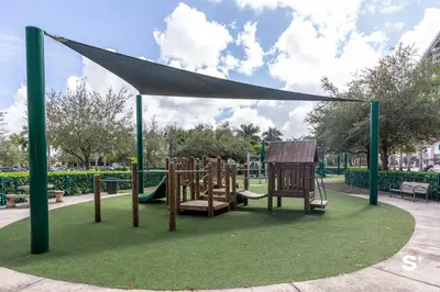 a playground in a park with a white canopy at Doral 2BD Condo with Skyline Views and Fitness Center in Miami