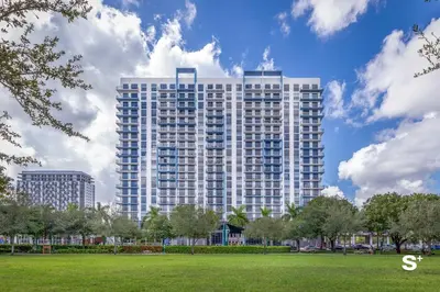a tall building with a park in front of it at Studio Apt in Downtown Doral in Miami