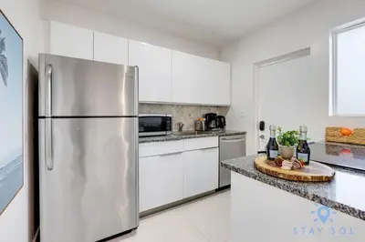 a kitchen with white cabinets and a stainless steel refrigerator at 809 Complex in Hollywood