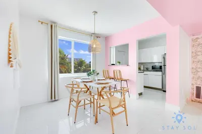 a dining room with pink walls and a table and chairs at 809 Complex in Hollywood