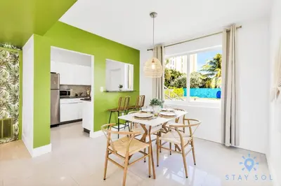 a kitchen and dining room with green walls and a table and chairs at 809 Complex in Hollywood