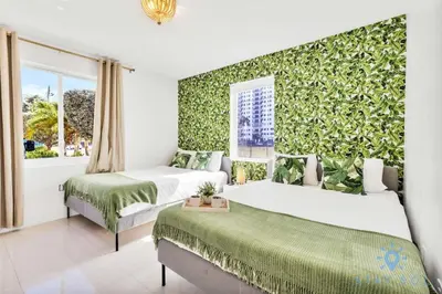 two beds in a room with a green wall at 809 Complex in Hollywood