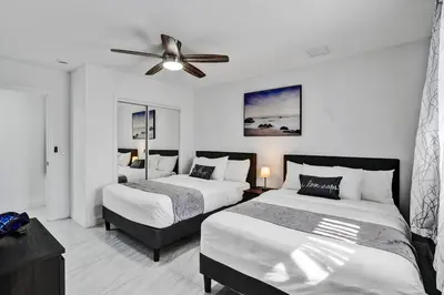a bedroom with two beds and a ceiling fan at WALK to Hollywood Beach Stylish 5BR and 4BA Villa in Hollywood