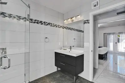a bathroom with a sink and a glass shower at WALK to Hollywood Beach Stylish 5BR and 4BA Villa in Hollywood
