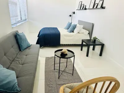 a living room with a bed and a couch at Palm Breeze Getaway in Hollywood