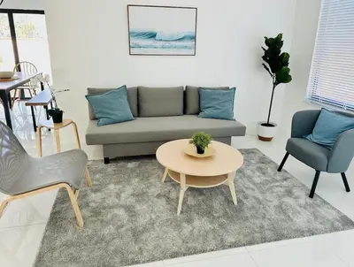 a living room with a couch and a table and chairs at Palm Breeze Getaway in Hollywood