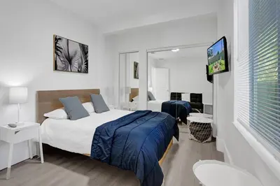 a bedroom with two beds and a flat screen tv at Palm Breeze Retreat in Hollywood