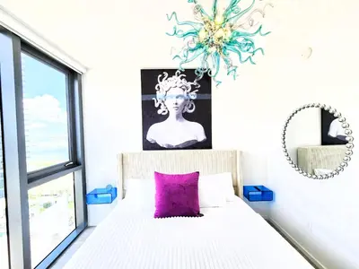 a bedroom with a bed with a purple pillow at 3BR Skyline Luxury with a 100 inch TV, Balcony & Prime Miami Location in Miami