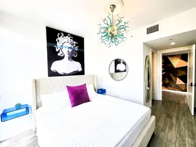 a bedroom with a white bed with a purple pillow at 3BR Skyline Luxury with a 100 inch TV, Balcony & Prime Miami Location in Miami