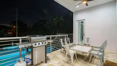 a grill on a balcony with a table and chairs at Villa Azul Luxe Retreat in Fort Lauderdale