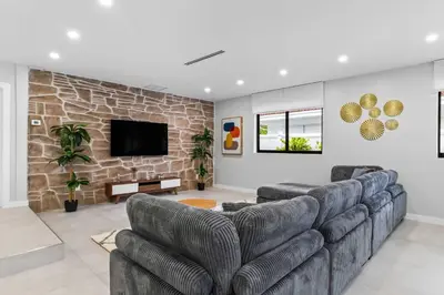 a living room with a couch and a tv at Lakefront Villa Tropical Backy in North Miami Beach