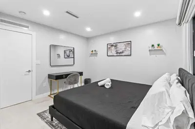 a bedroom with a black bed and a desk at Lakefront Villa Tropical Backy in North Miami Beach
