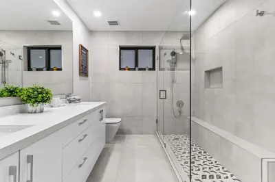 a white bathroom with a shower and a toilet at Lakefront Villa Tropical Backy in North Miami Beach