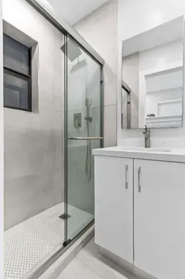 a white bathroom with a shower and a sink at Lakefront Villa Tropical Backy in North Miami Beach