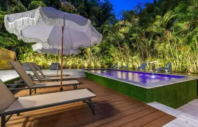 a swimming pool with chairs and an umbrella on a deck at Brand new Luxurious Villa in Hollywood