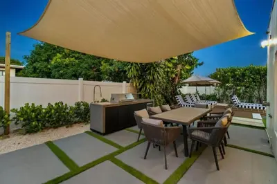 a patio with a table and chairs under a large umbrella at New Construction Villa Top Location Jacuzzi Bkb CT in Miami