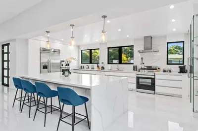 a white kitchen with blue chairs and a large island at New Construction Villa Top Location Jacuzzi Bkb CT in Miami