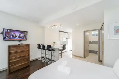 a bedroom with a bed and a desk with chairs at Casa Colaretta By At Mine Hospitality in Miami Beach