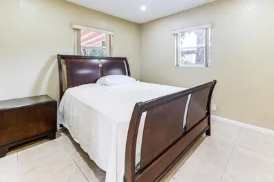 a bedroom with a large bed and two windows at 3 Mi to Dania Beach Pier Convenient Apartment! in Dania Beach