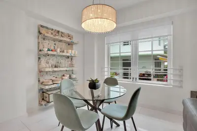 a dining room with a glass table and chairs at 2BR Art Deco Retreat Steps Away from the Beach in Miami Beach