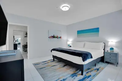 a white bedroom with a bed and a desk at 2BR Art Deco Retreat Steps Away from the Beach in Miami Beach