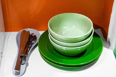 a stack of green bowls and plates on a table at Luxury Miami Studio Next to Beach & Airport in Miami