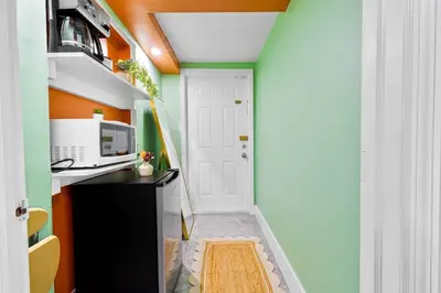 a small hallway with an orange and green wall at Luxury Miami Studio Next to Beach & Airport in Miami