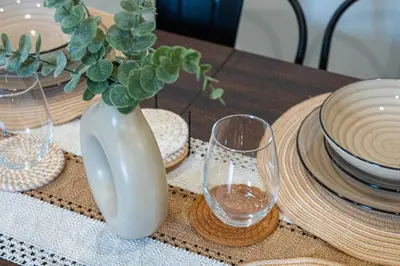 a wooden table with a vase and glasses on it at Modern Miami Home minutes to Wynwood & Downtown in Miami