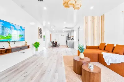 a living room with an orange couch and a table at Modern Miami Home minutes to Wynwood & Downtown in Miami