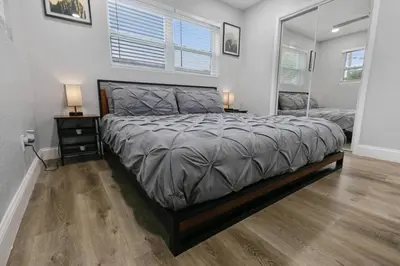 a bedroom with a large bed and a mirror at Renovated Home in Hollywood in Hollywood