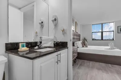 a white bathroom with a sink and a bed at Urban Escape 2 Bed Unit In Miami near Whole Foods in North Miami