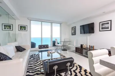 a living room with a couch and a table at Large 2 Bedroom Oceanfront at Roney Palace in South Beach in Miami Beach