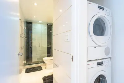 a bathroom with a washing machine and a toilet at Large 2 Bedroom Oceanfront at Roney Palace in South Beach in Miami Beach