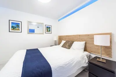 a bedroom with a large white bed and a lamp at Large 2 Bedroom Oceanfront at Roney Palace in South Beach in Miami Beach