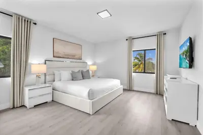 a white bedroom with a bed and two windows at Casa Bella - New & Stylish Family-Friendly Home in Miami