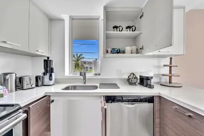 a white kitchen with a sink and a window at Waterfront Luxury Kosher Condo with Rooftop Pool, Bay Harbor Islands in Miami Beach