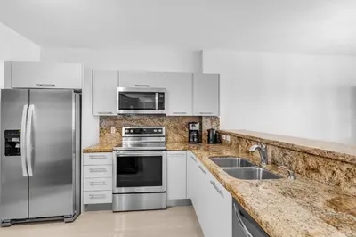 a kitchen with white cabinets and stainless steel appliances at Waterview Luxury 2-Bedroom Condo Sunny Isles Beach in Sunny Isles Beach