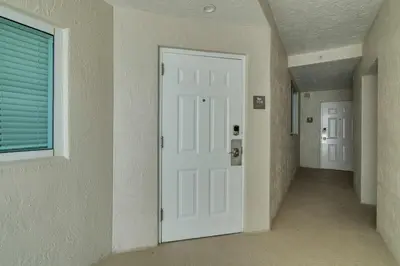 an empty hallway with a white door and a window at Waterview Luxury 2-Bedroom Condo Sunny Isles Beach in Sunny Isles Beach