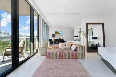 a bedroom with a king sized bed and a balcony at Oceanfront Elegance at W Hotel in Miami Beach