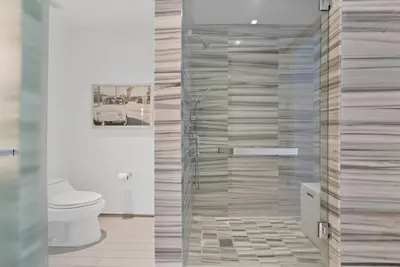a bathroom with a toilet and a glass shower at Oceanfront Elegance at W Hotel in Miami Beach