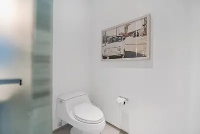 a bathroom with a toilet with a picture on the wall at Oceanfront Elegance at W Hotel in Miami Beach