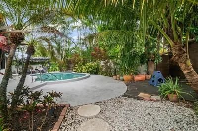 a backyard with a swimming pool and palm trees at Oasis with Pool & Cold Plunge-Near Beach & Nightlife in Fort Lauderdale